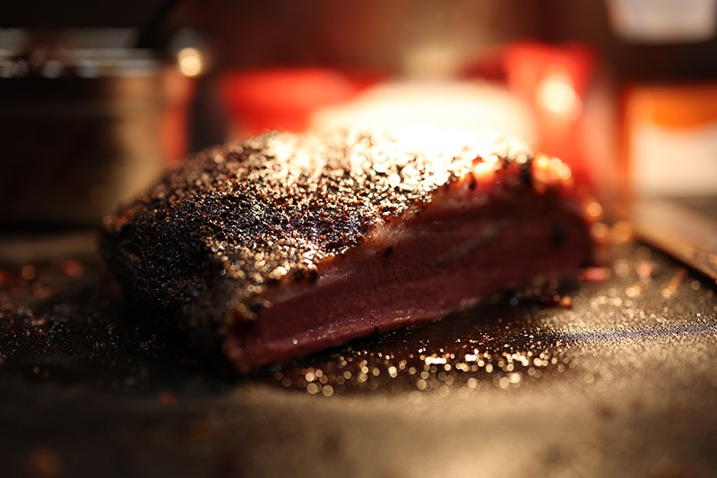 Vasta grillistä otettu BBQ-pihviannos, jonka pinnalle valo osuu. 