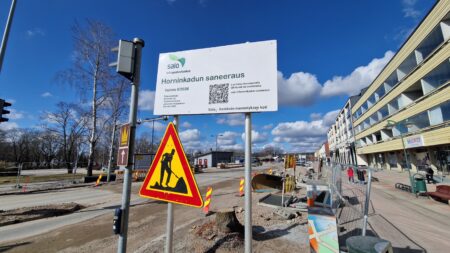 Kadun päässä katutyömaa-liikennemerkki ja katusaneerauksesta kertova infokyltti.